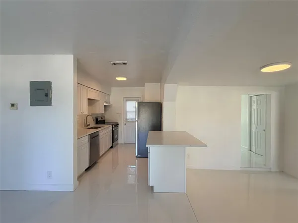 a kitchen with a refrigerator and a sink