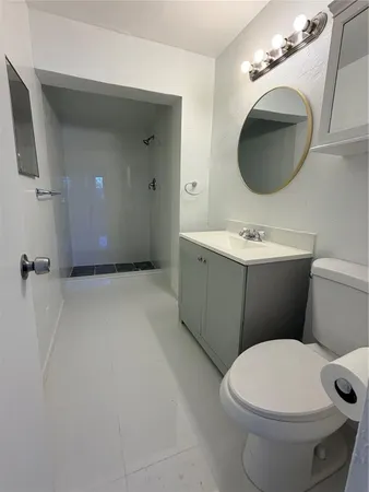 a bathroom with a toilet a sink and mirror