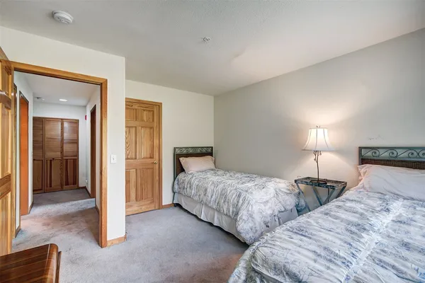 a bedroom with two beds and lamp