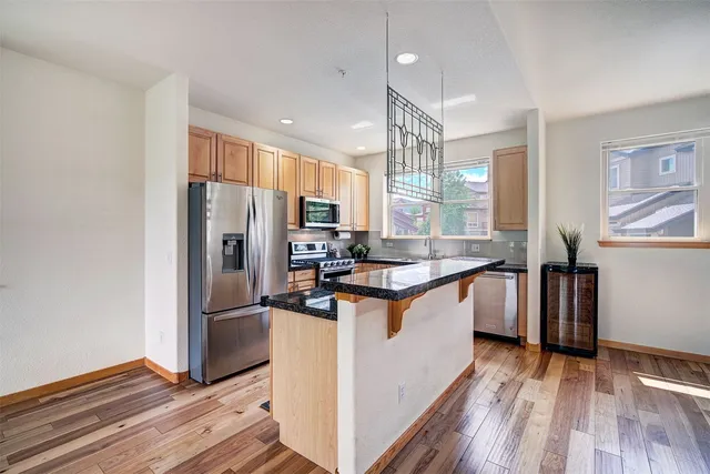 a kitchen with stainless steel appliances granite countertop a refrigerator a sink and a stove