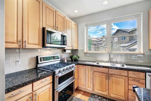 a kitchen with granite countertop a stove a sink and a granite counter tops