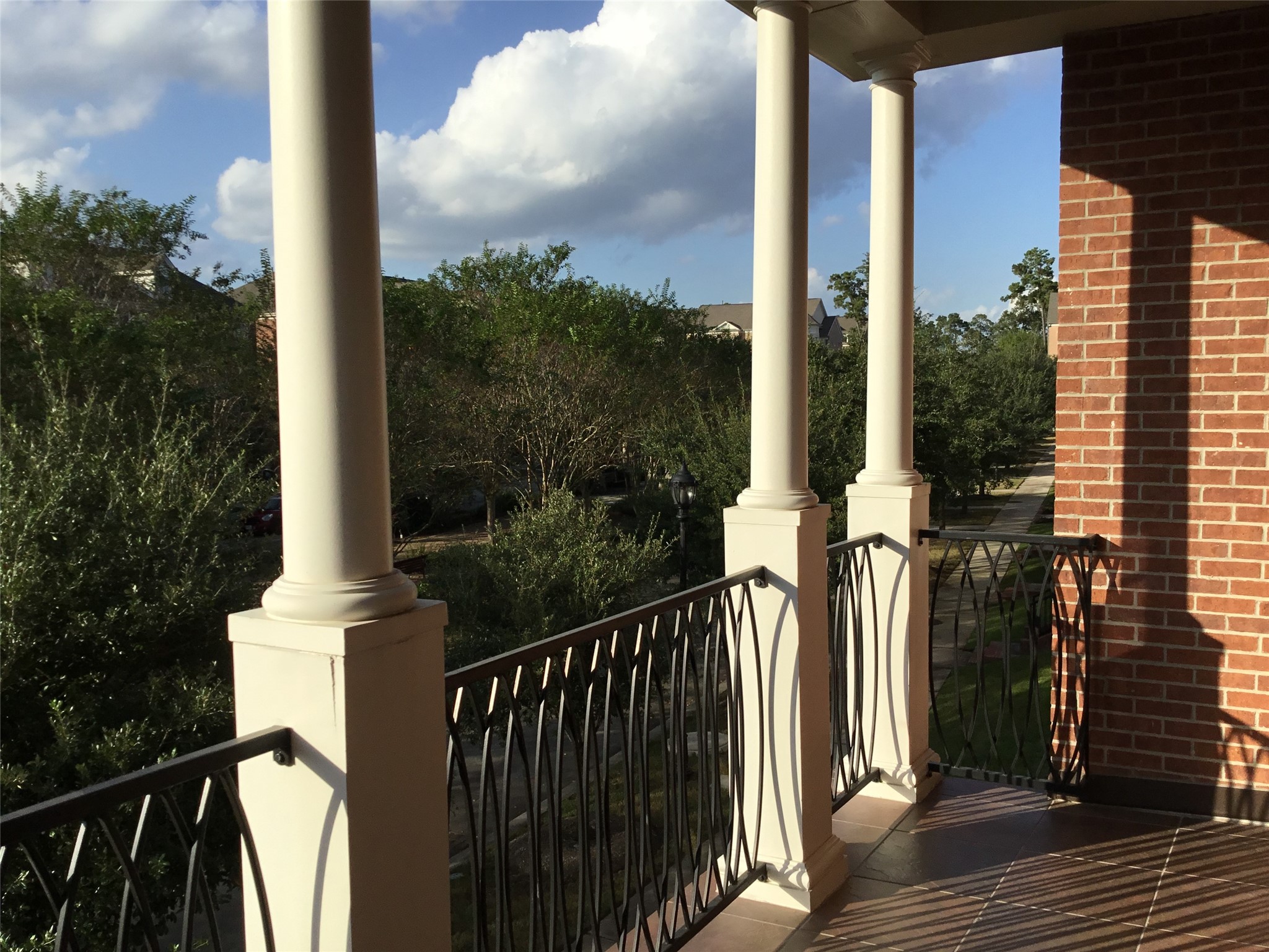 2 Islewood Boulevard Spring, TX 77380 - Photo 34 of 48 A charming outdoor balcony with elegant columns and wrought iron railing, offering a peaceful view of lush greenery and tree top view. Ideal for relaxing and enjoying the scenery or an afternoon beverage as the sunsets.