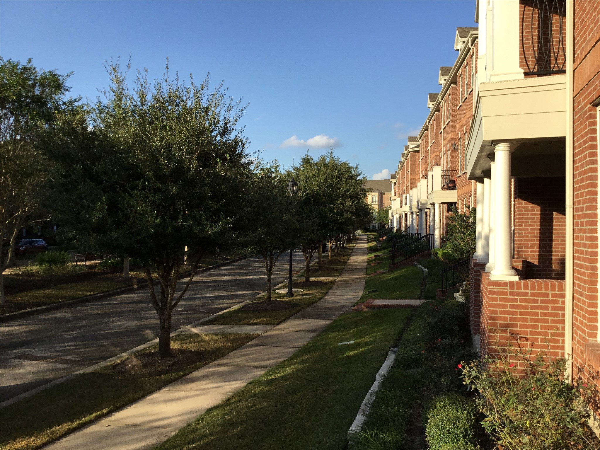 2 Islewood Boulevard Spring, TX 77380 - Photo 35 of 48 This photo shows a row of charming brick townhouses, set along a tree-lined sidewalk. The area looks peaceful and well-maintained, perfect for comfortable urban living.