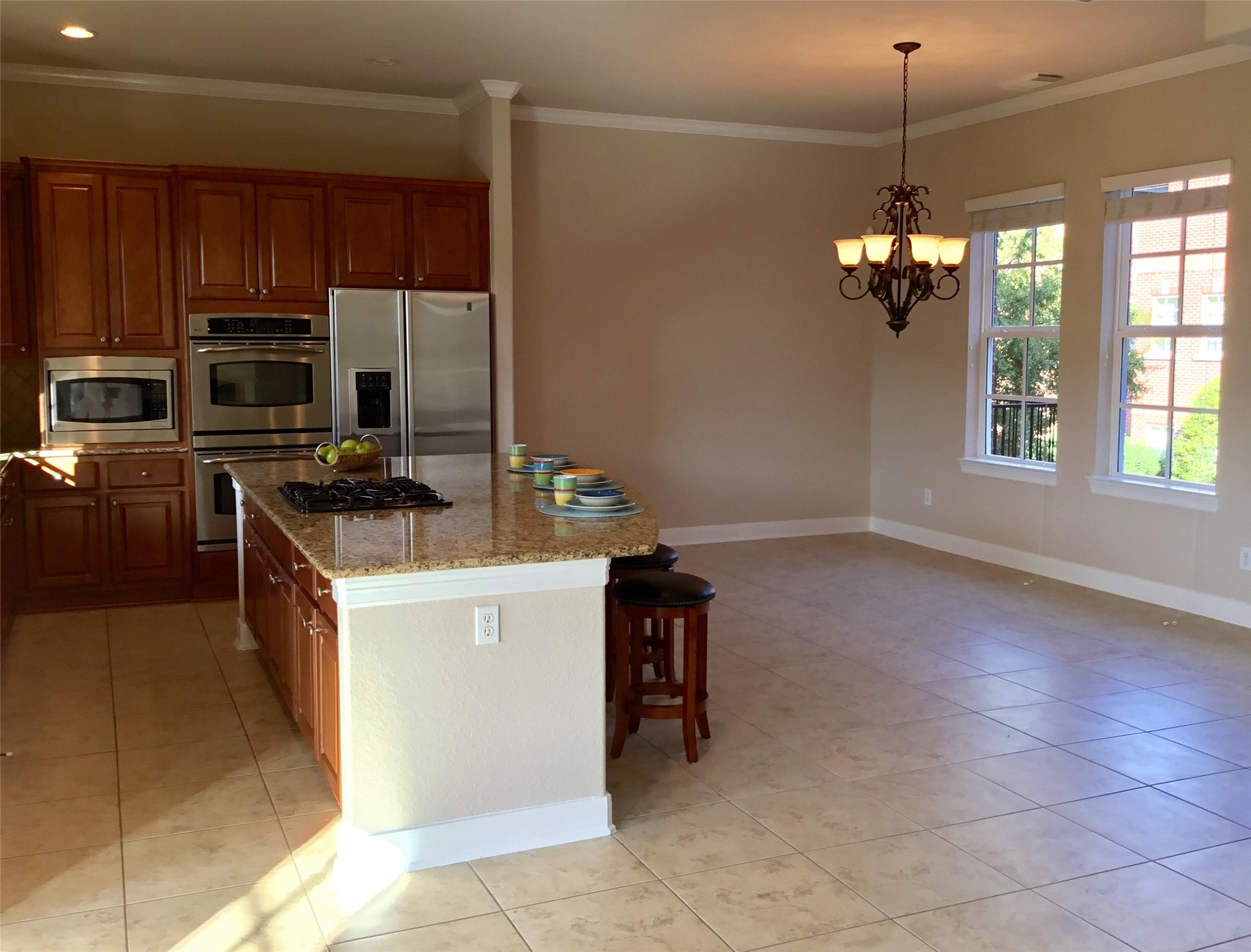 2 Islewood Boulevard Spring, TX 77380 - Photo 5 of 48 A spacious kitchen and dining area with tiled floors, wooden cabinets, stainless steel appliances, and a large granite island. The room features ample natural light from multiple windows.