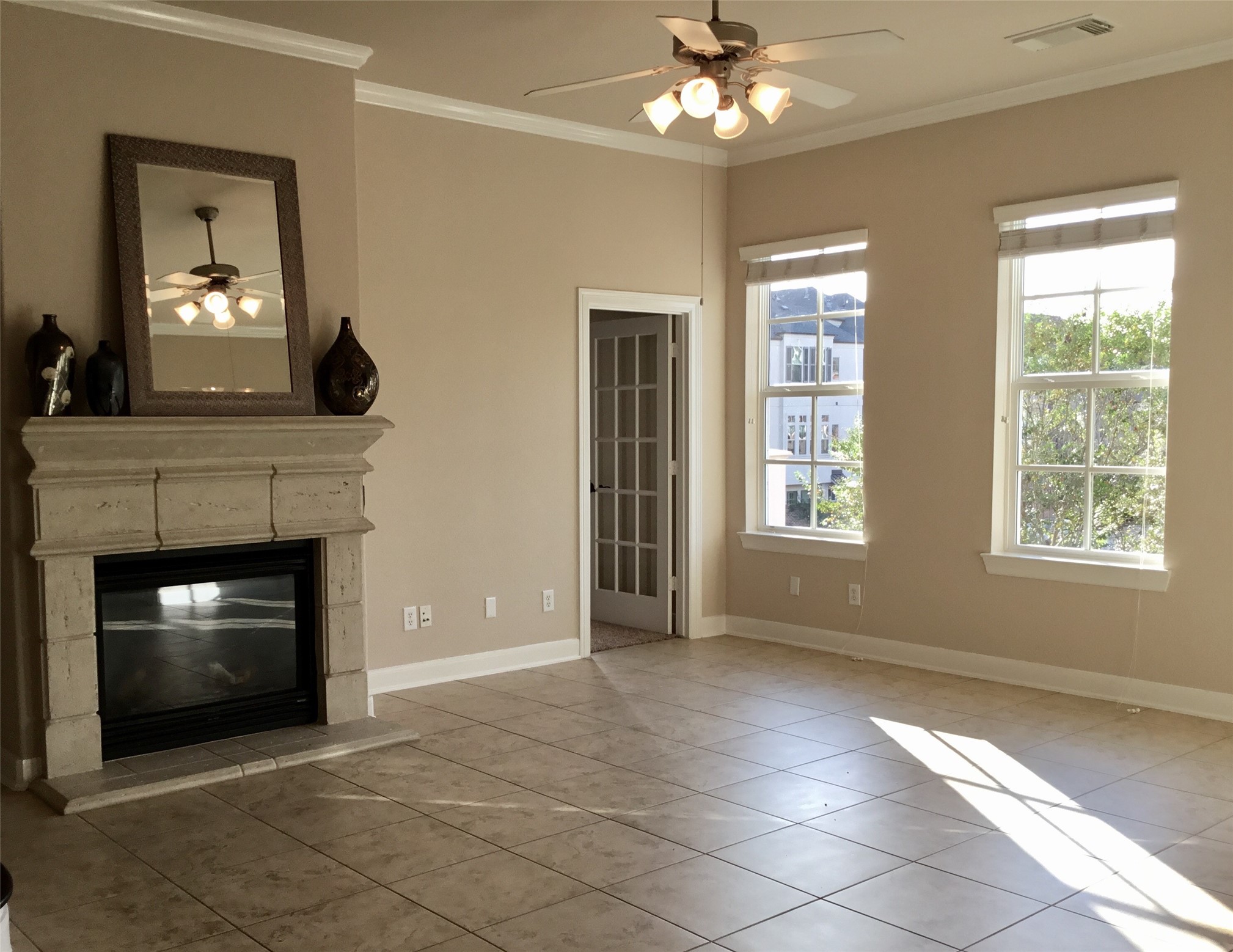 2 Islewood Boulevard Spring, TX 77380 - Photo 10 of 48 Bright living room with an easy to care for tile floor, a classic stone fireplace and mantle. Large windows provide natural light, and access to a lovely balcony. The room includes a doorway with French doors, leading to a private study.
