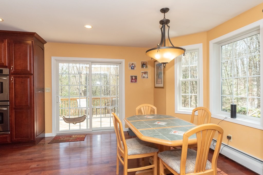 65 Williamsville Road Phillipston, MA 01331 - Photo 14 of 38 a dining room with wooden floor a chandelier a glass table and windows