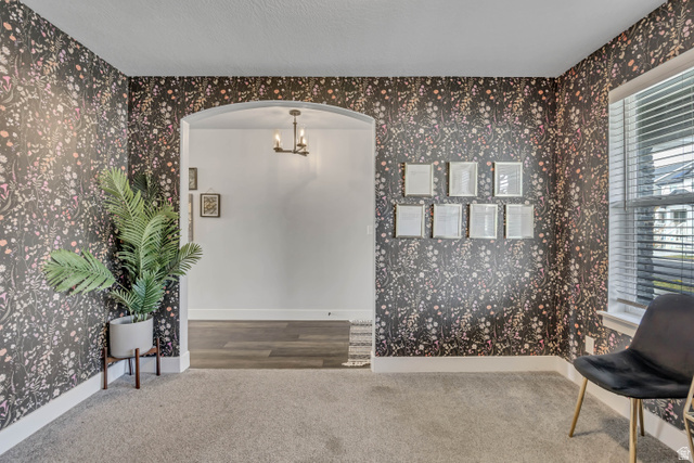 1577 Quailhill Road Saratoga Springs, UT 84045 - Photo 5 of 46 Living area featuring arched walkways, carpet floors, wallpapered walls, and a chandelier