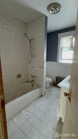 a bathroom with a granite countertop sink a toilet and bathtub