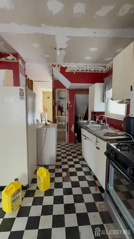 a kitchen with a stove and a black white checkered floor