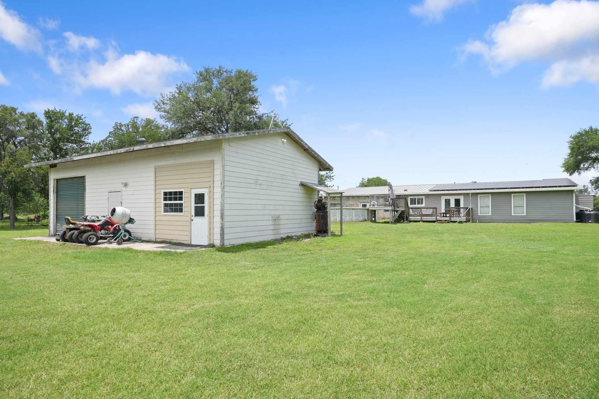 9725 Bock Road Buda, TX 78610 - Photo 31 of 32 A spacious backyard provides ample green space with a detached outbuilding and a deck for outdoor living.
