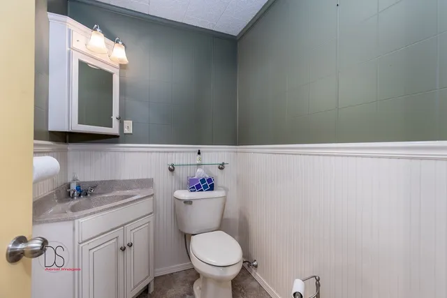 a bathroom with a toilet sink and mirror