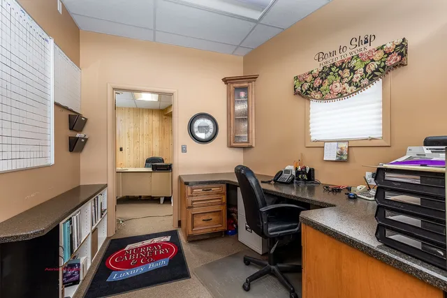 a view of a workspace with furniture and a window