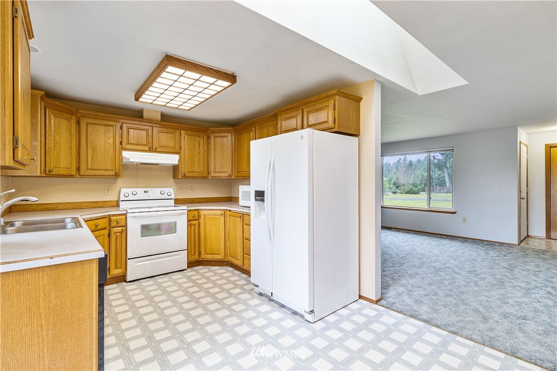704 West Avery Road Winlock, WA 98596 - Photo 8 of 32 a kitchen with a refrigerator and cabinets