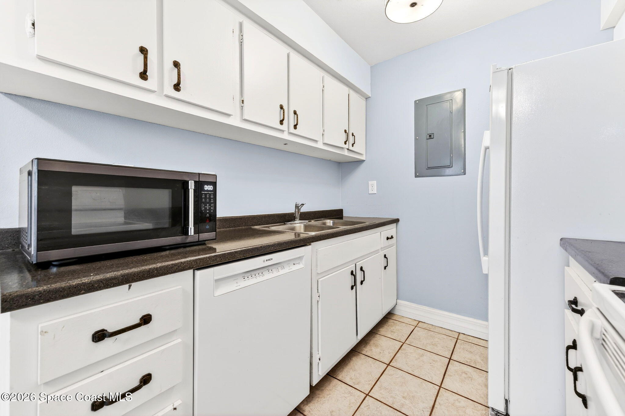 1225 North Wickham Road, Unit 422 Melbourne, FL 32935 - Photo 12 of 32 a kitchen with granite countertop white cabinets and stainless steel appliances