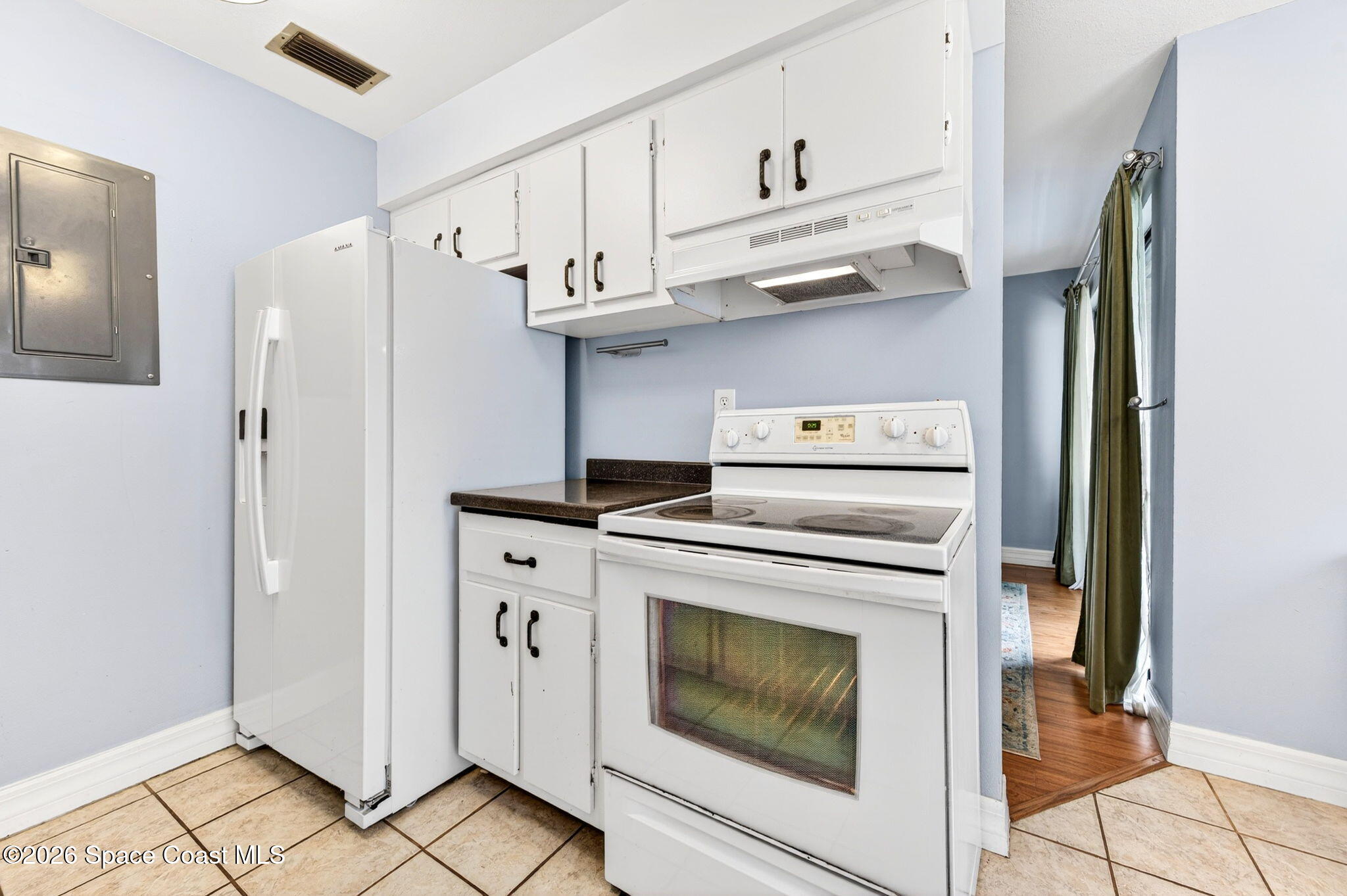 1225 North Wickham Road, Unit 422 Melbourne, FL 32935 - Photo 13 of 32 a kitchen with stainless steel appliances white cabinets and white appliances