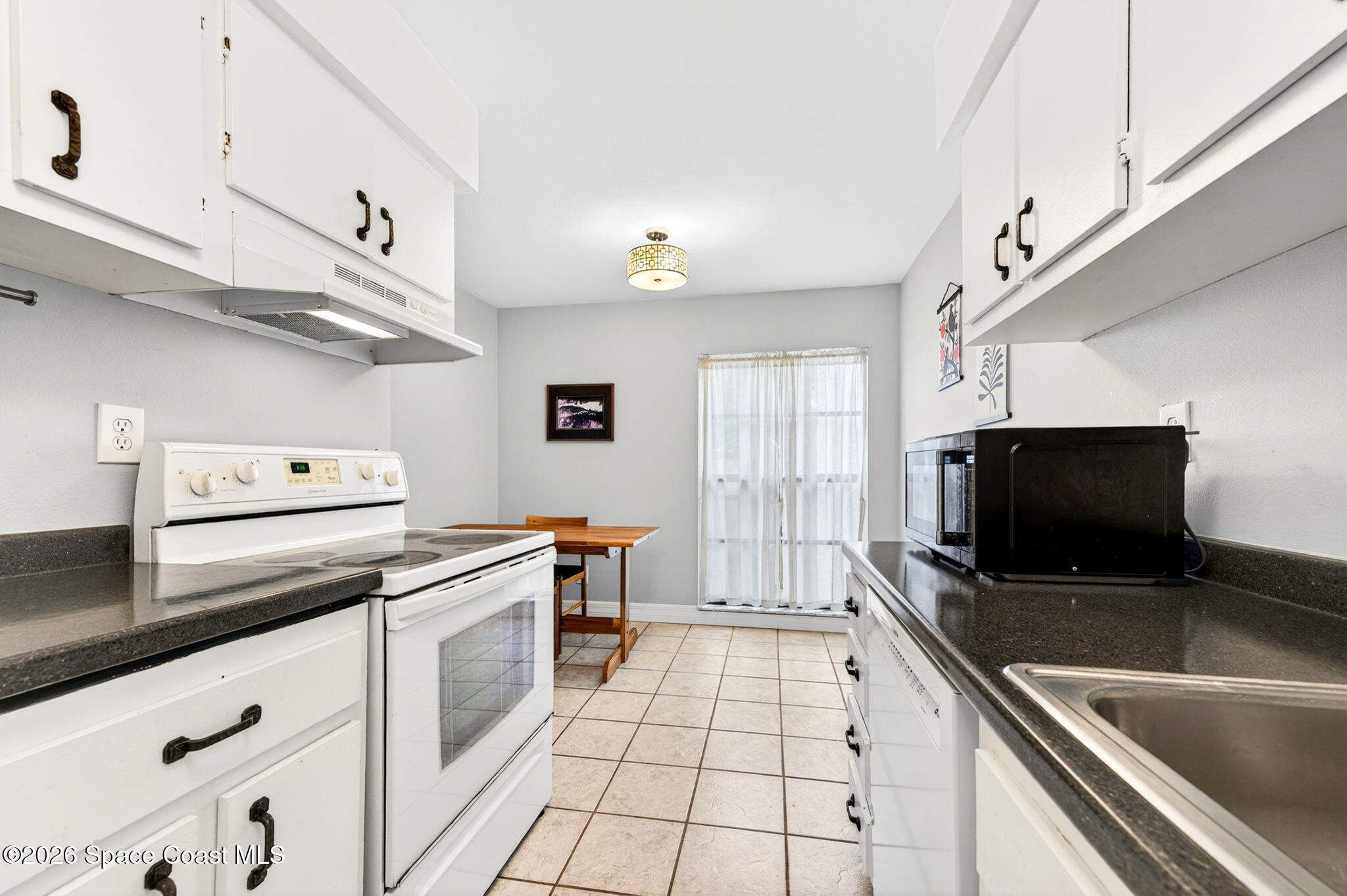 1225 North Wickham Road, Unit 422 Melbourne, FL 32935 - Photo 14 of 32 a kitchen with stainless steel appliances a stove microwave and sink