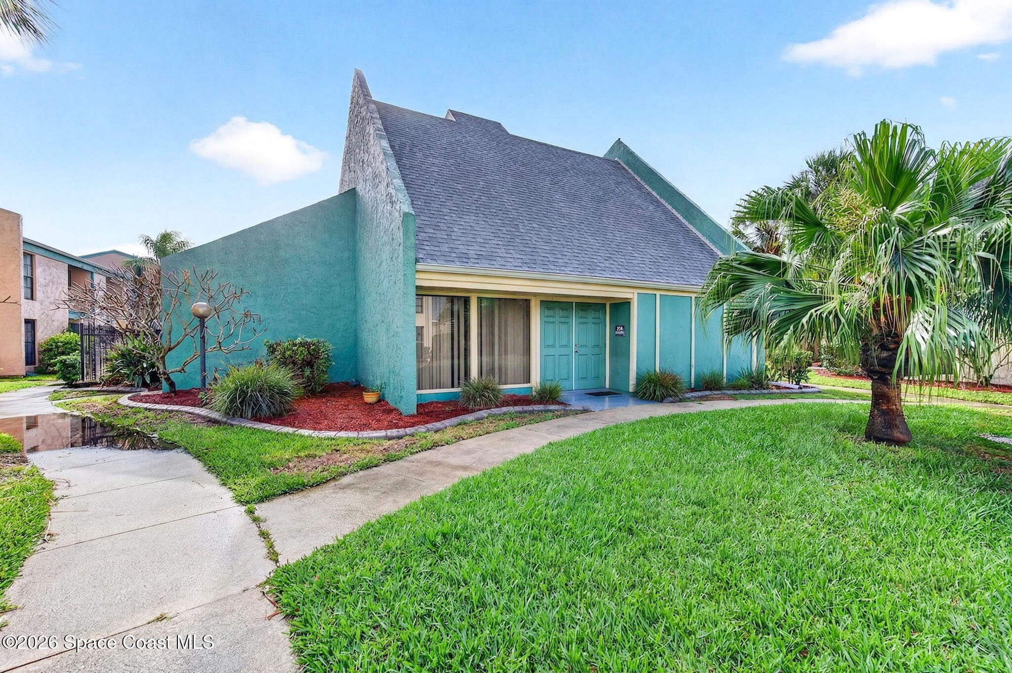 1225 North Wickham Road, Unit 422 Melbourne, FL 32935 - Photo 28 of 32 a view of a house with a yard and plants