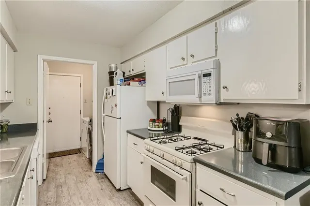 a kitchen with white cabinets and white appliances