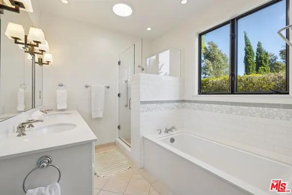 a bathroom with a tub sink and mirror