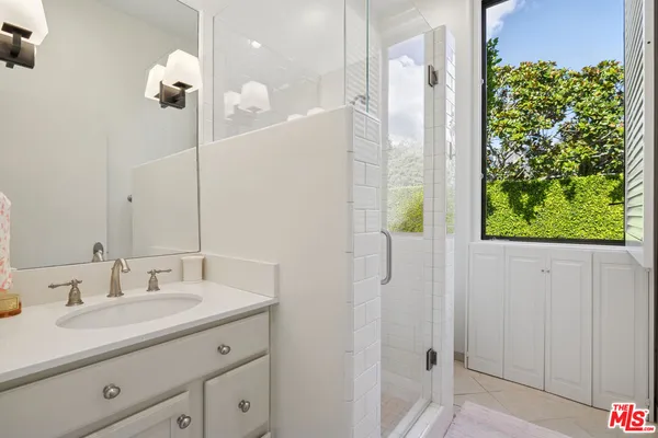 a bathroom with a granite countertop sink a shower and a mirror
