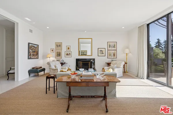 a living room with furniture a fireplace and a large mirror