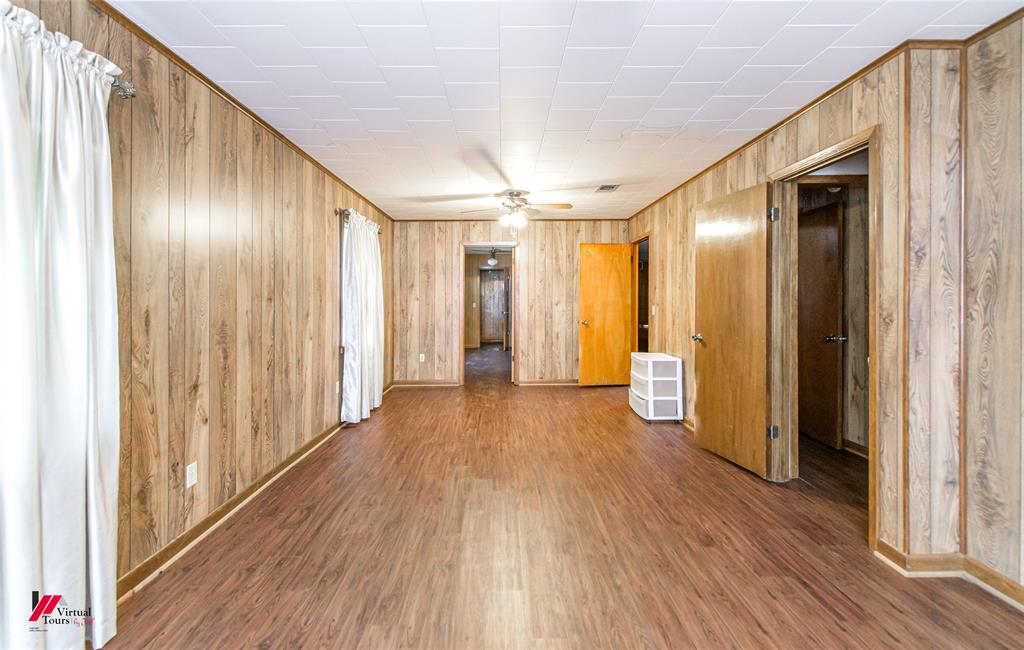 1732 King Orchard Road Sarepta, LA 71071 - Photo 18 of 40 Spare room with baseboards, wood finished floors, ceiling fan, and wood walls