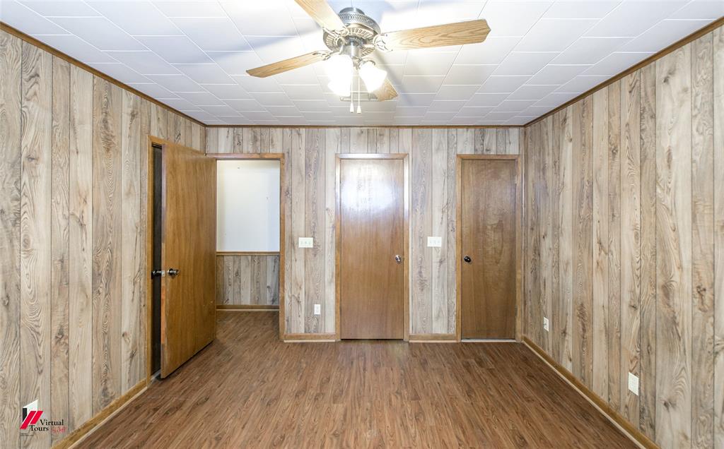 1732 King Orchard Road Sarepta, LA 71071 - Photo 22 of 40 Unfurnished bedroom featuring baseboards, ceiling fan, wood finished floors, and wooden walls