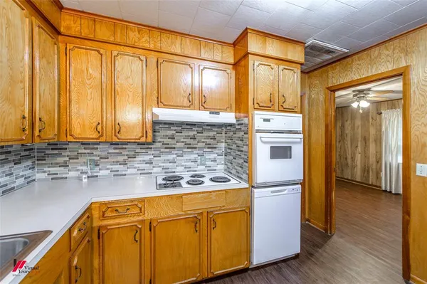 a kitchen with stainless steel appliances granite countertop a refrigerator a stove and a sink with wooden floor