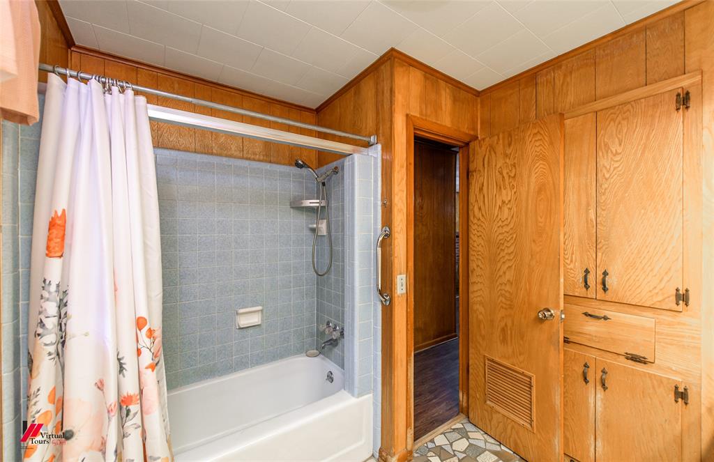 1732 King Orchard Road Sarepta, LA 71071 - Photo 33 of 40 Bathroom with visible vents, wood walls, and shower / bath combo with shower curtain