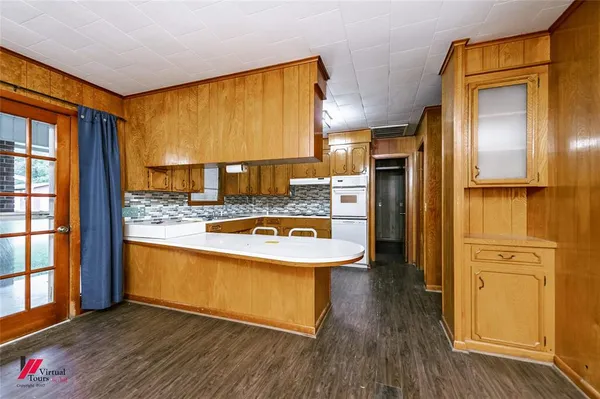 a view of a kitchen with refrigerator and wooden floor