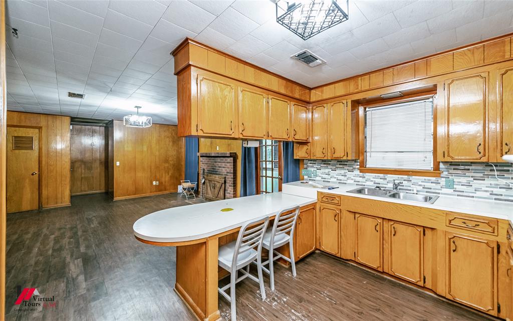 1732 King Orchard Road Sarepta, LA 71071 - Photo 39 of 40 Kitchen with a peninsula, light countertops, dark wood-type flooring, a breakfast bar, and wooden walls