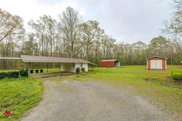 a front view of house with yard and trees in the background