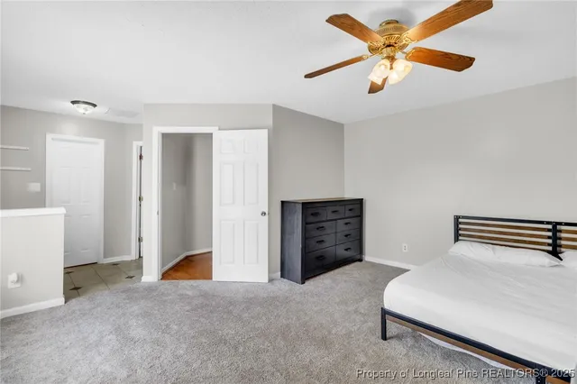 a bedroom with a bed and a ceiling fan