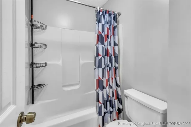 a bathroom with a shower curtain and a toilet