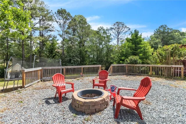 a table and chairs with wooden fence