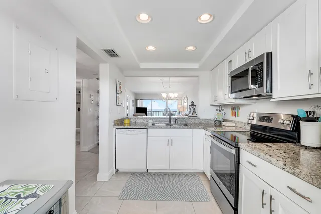 a kitchen with a sink a stove a refrigerator and cabinets