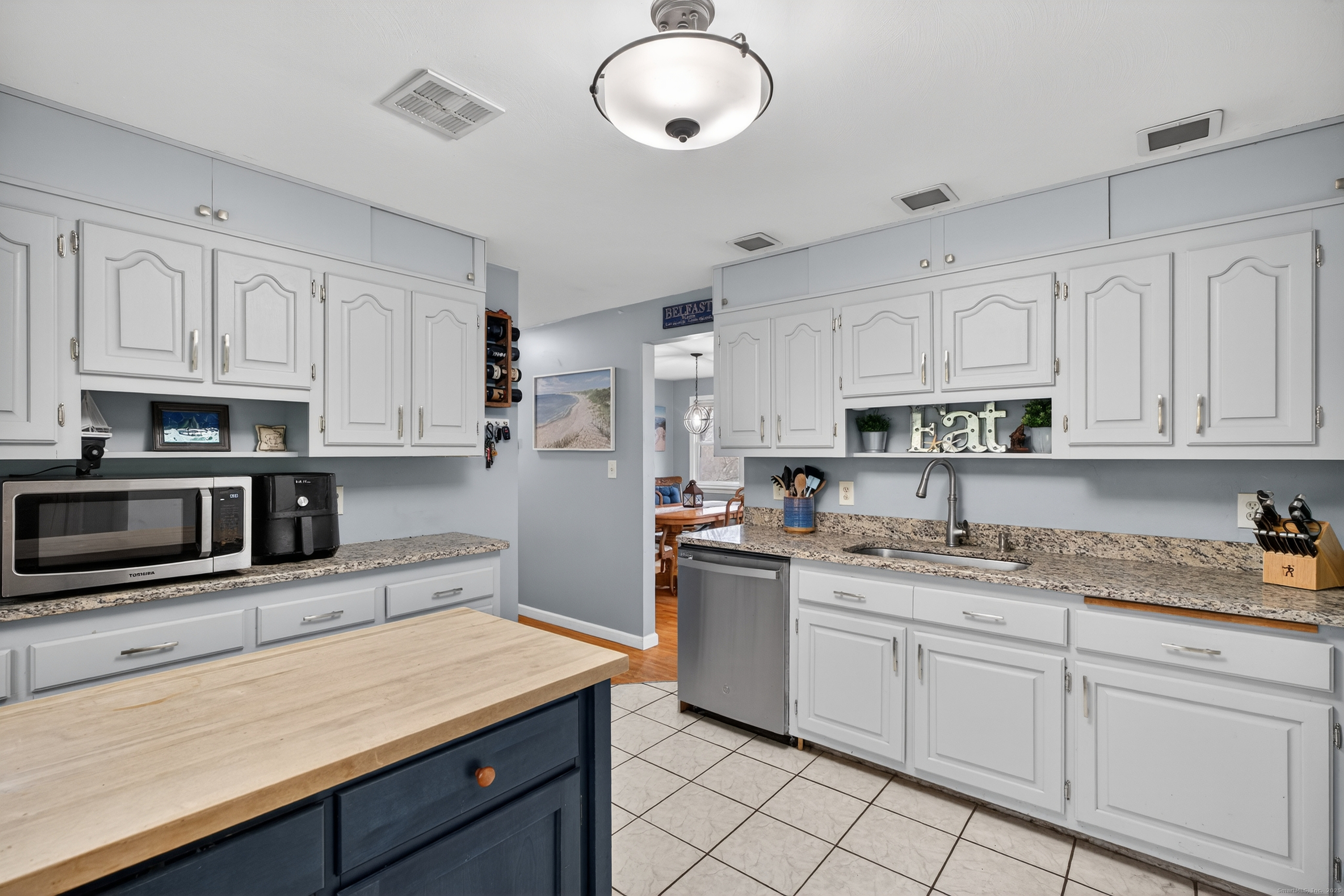91 Highview Terrace Middletown, CT 06457 - Photo 19 of 39 a kitchen with stainless steel appliances granite countertop a sink dishwasher stove and white cabinets with wooden floor