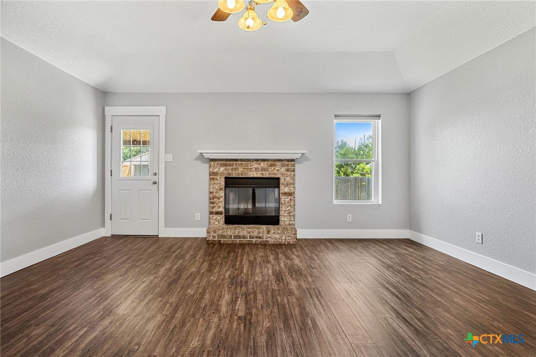 3208 Viewcrest Drive Killeen, TX 76549 - Photo 3 of 15 an empty room with wooden floor a fireplace and windows