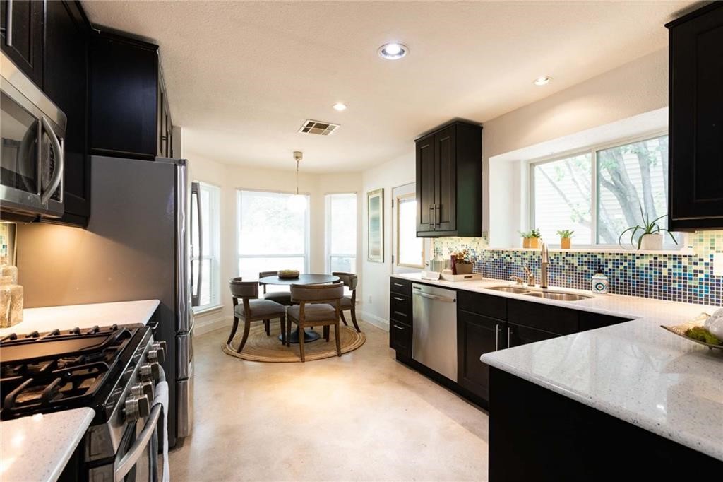 a large kitchen with a table and chairs