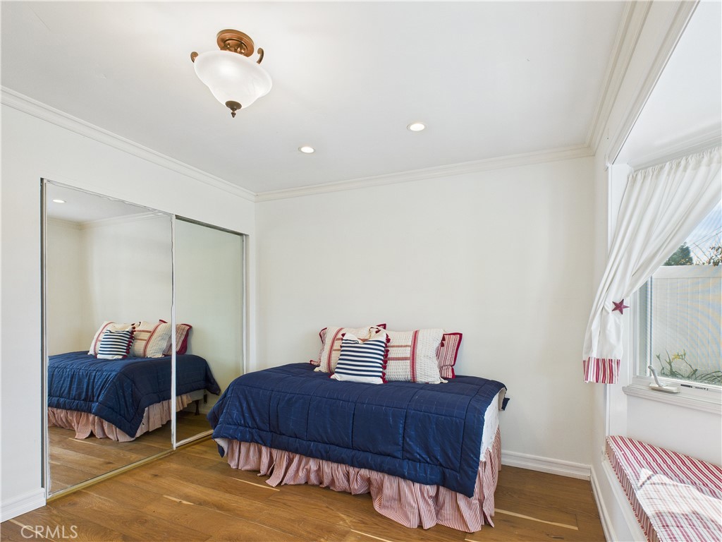 2857 Ellesmere Avenue Costa Mesa, CA 92626 - Photo 23 of 45 a bedroom with a bed and wooden floor