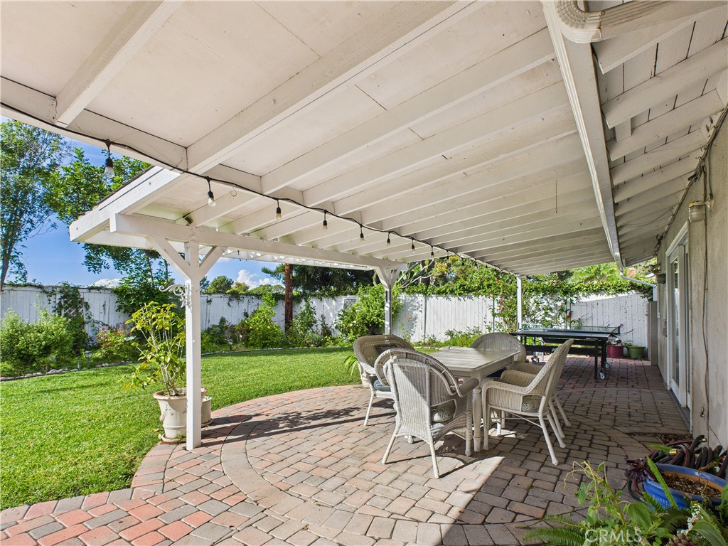 2857 Ellesmere Avenue Costa Mesa, CA 92626 - Photo 26 of 45 a view of a patio with table and chairs under an umbrella