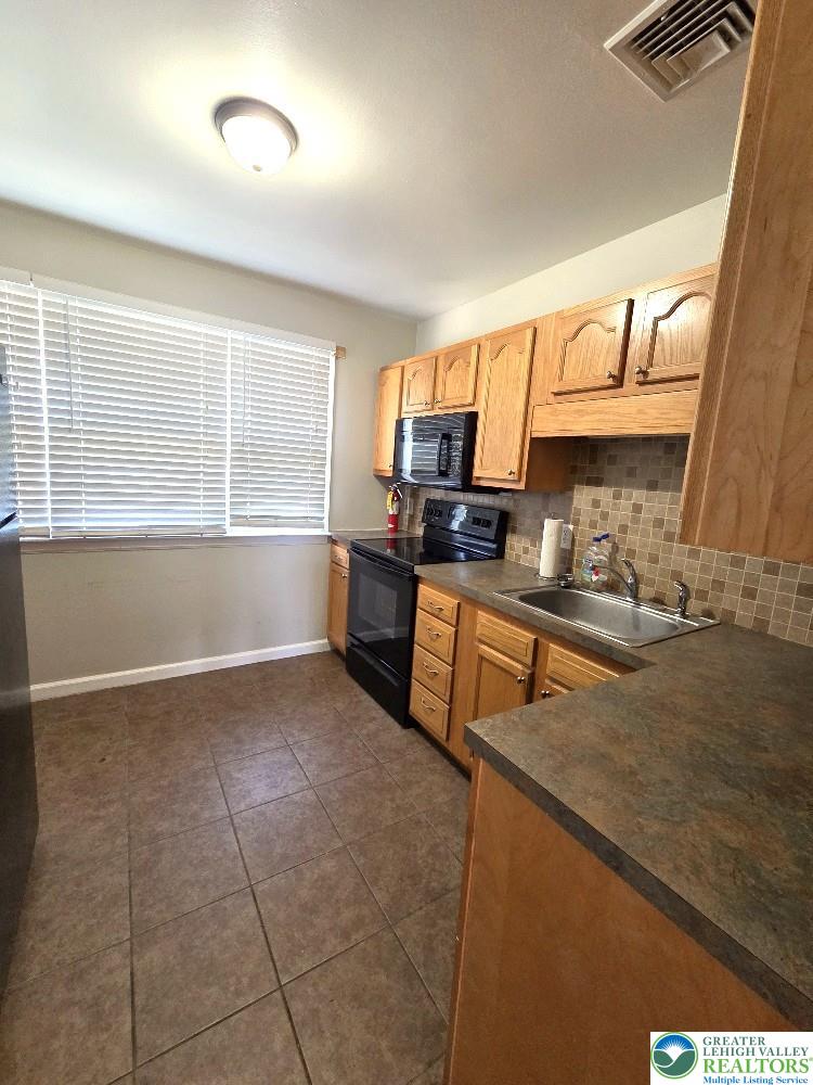1747 Schoenersville Road Bethlehem, PA 18018 - Photo 6 of 13 Functional kitchen with ample cabinetry and resilient tile flooring.