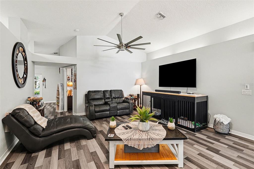 11428 Dorian Court New Port Richey, FL 34654 - Photo 14 of 30 a living room with furniture a flat screen tv and kitchen view