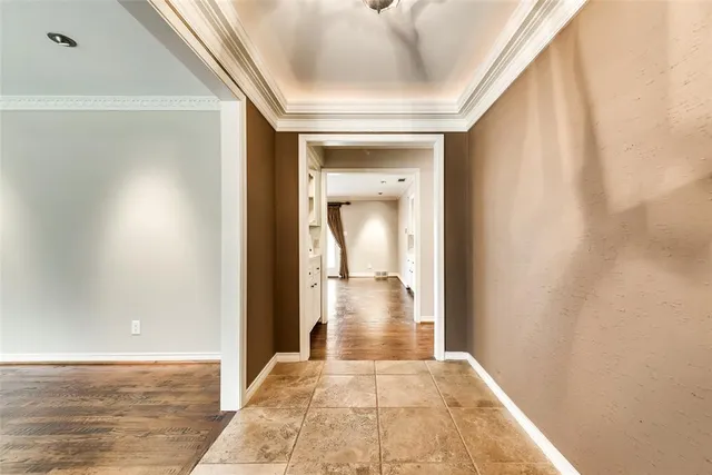 a view of a hallway with wooden floor and a bathroom
