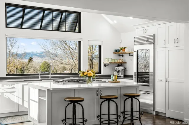 a kitchen with stainless steel appliances granite countertop a sink and a refrigerator