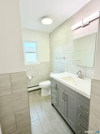 a spacious bathroom with a double vanity sink toilet and a mirror