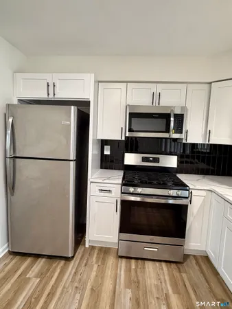 a kitchen with a stove a refrigerator and a microwave