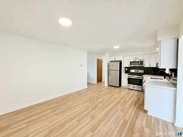 a view of kitchen with stove top oven and refrigerator