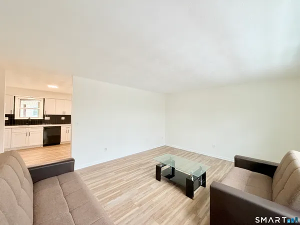 a living room with furniture and kitchen view