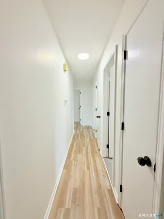 a view of a hallway with wooden floor and staircase